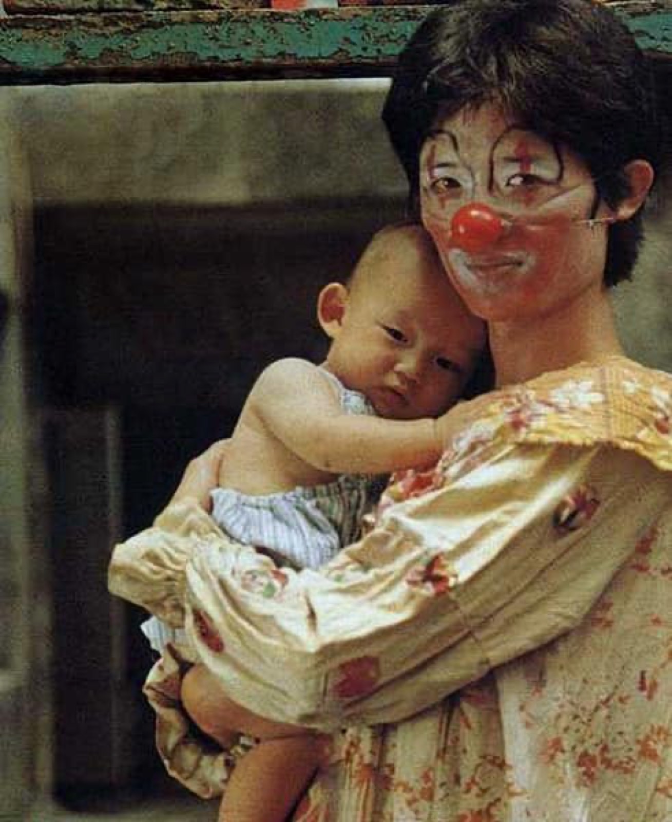 《兒子的大玩偶》劇照,畫著小丑妝的人抱著嬰兒