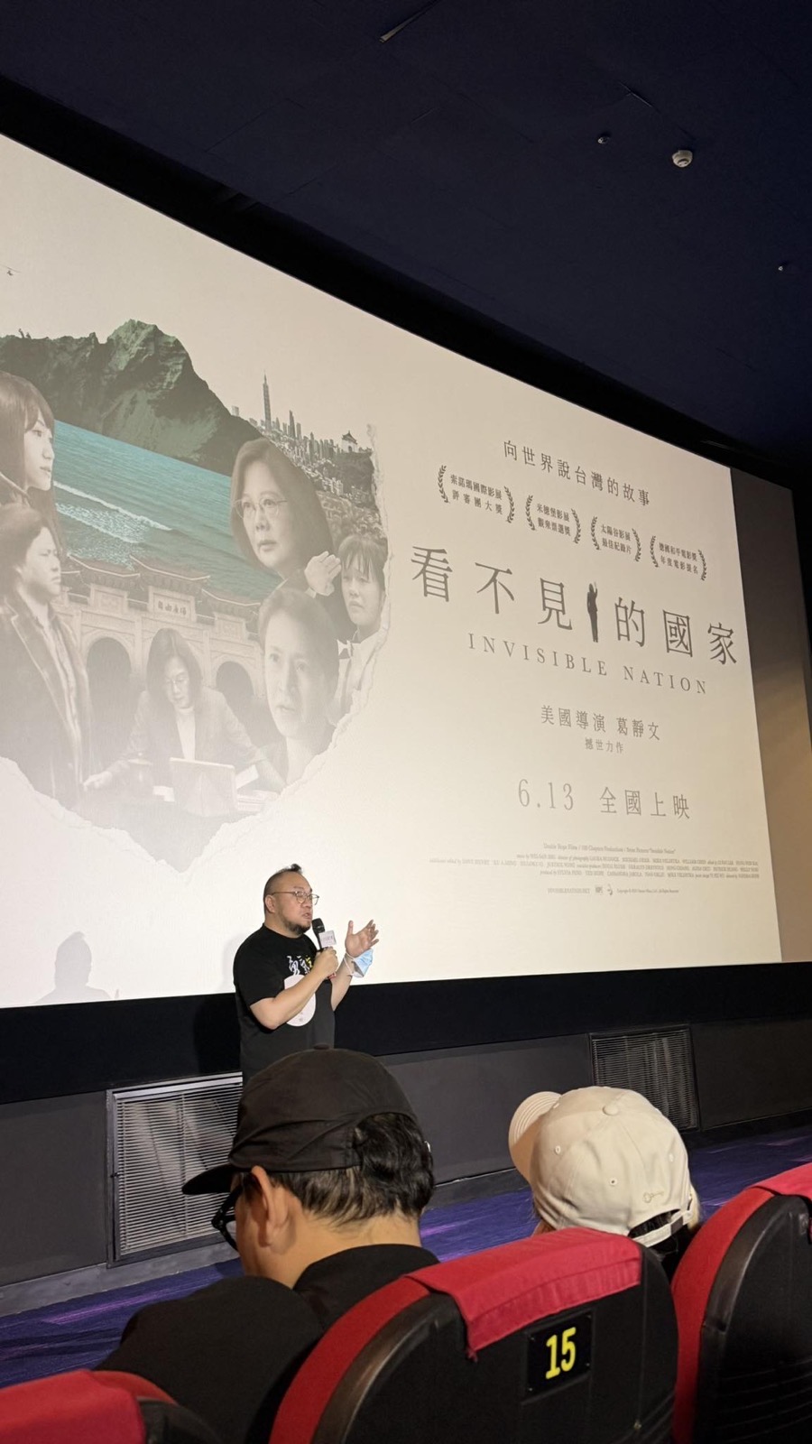 《看不見的國家》放映後,講者站在銀幕前拿麥克風分享